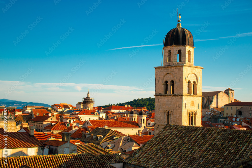 Heart of the old town of Dubrovnik, church belltower on the main street of Stradun, rising above the red rooftops of many old small houses. Town famous for its heritage and unesco protection