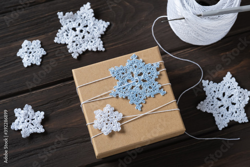 Idea gifts wrapping of the Christmas gift and decoration with knitted snowflakes. photo