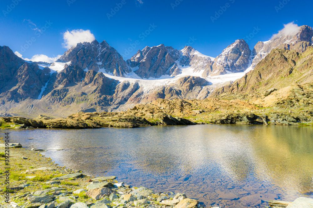 Clear sky over the rocky peaks of Bernina Group and Forbici lake in summer, Valmalenco, Valtellina, Lombardy, Italy Clear sky over the rocky peaks of Bernina Group and Forbici lake in summer, Valmalenco, Valtellina, Lombardy, Italy