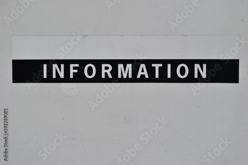 Prominent 'Information' Sign Painted on White Wall 