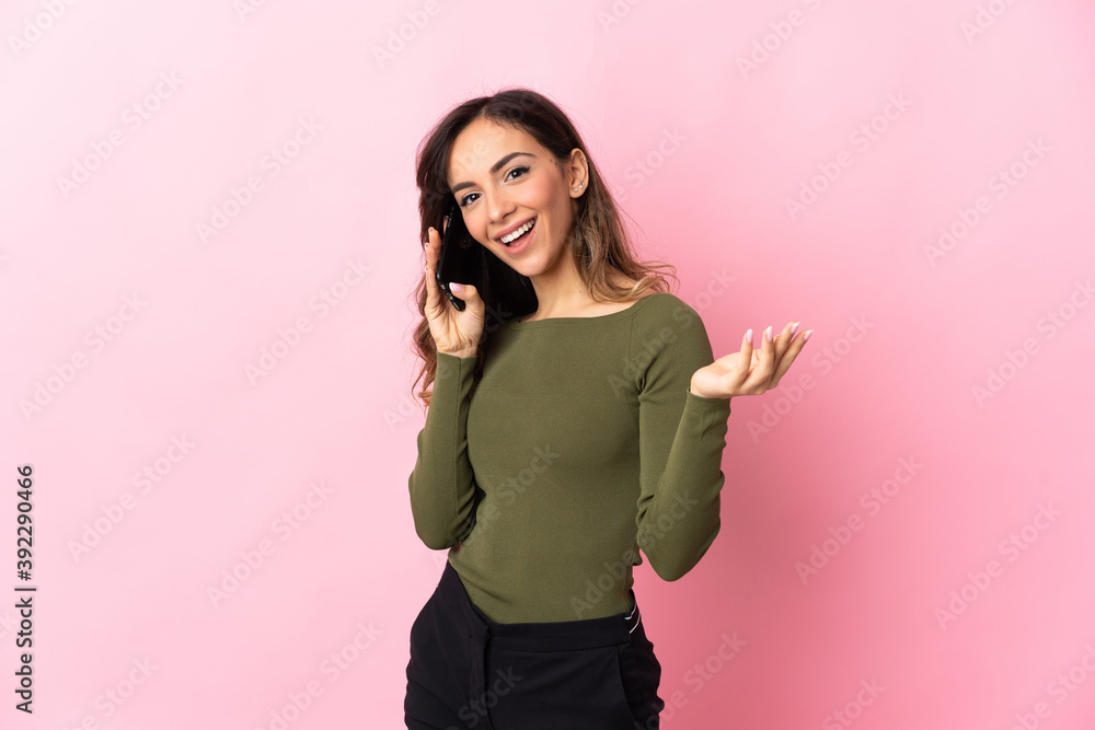 Young caucasian woman isolated on pink background keeping a conversation with the mobile phone with someone Young caucasian woman isolated on pink background keeping a conversation with the mobile phone with someone