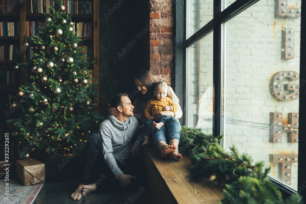  A loving daddy with his little son on the cheec near Christmas tree. New Year mood
