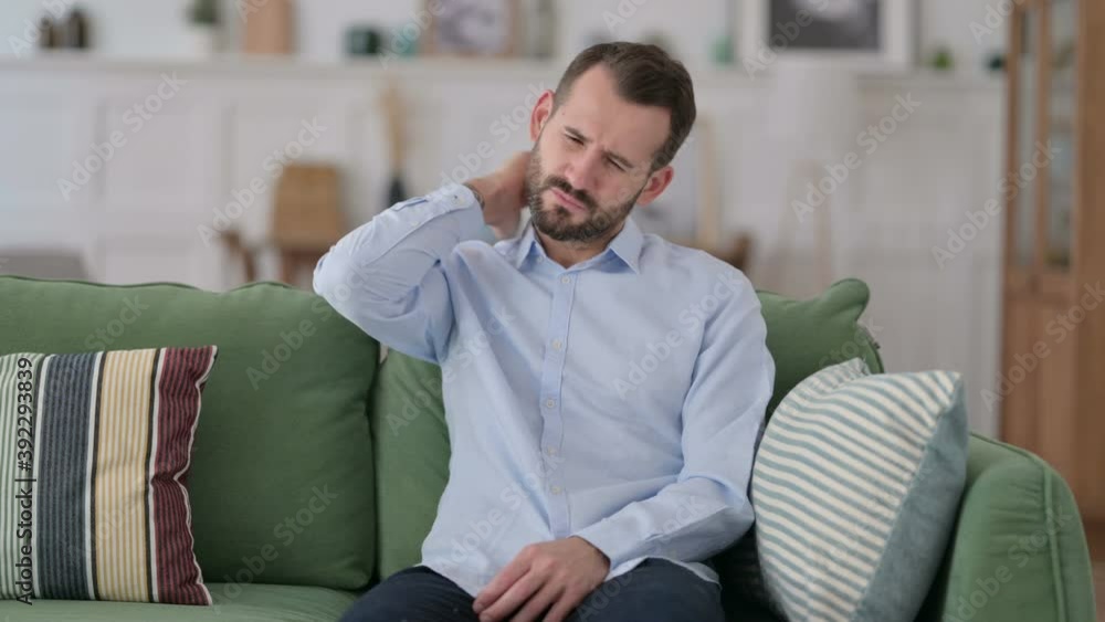 Exhausted Young Man having Neck Pain on Sofa Exhausted Young Man having Neck Pain on Sofa