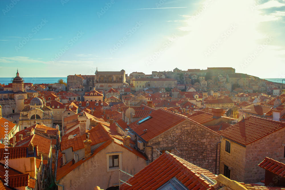 Rooftops inside the old city of Dubrovnik, old stone houses with bright red brick roofs. As seen while walking along the city walls on a bright autumn day during the covid season