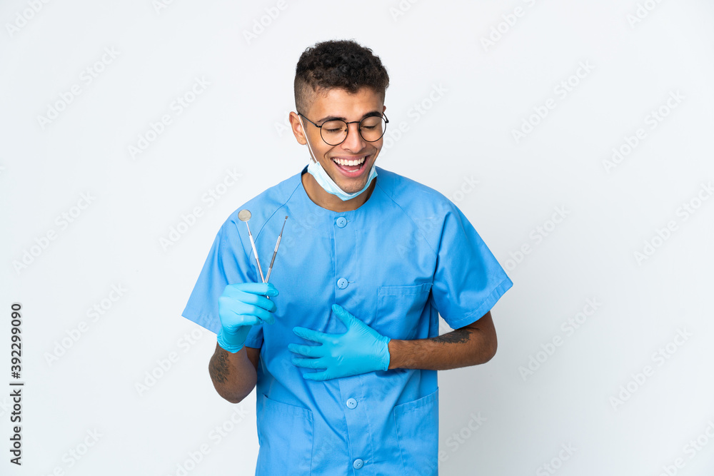 Brazilian dentist holding tool isolated on white background smiling a lot Brazilian dentist holding tool isolated on white background smiling a lot
