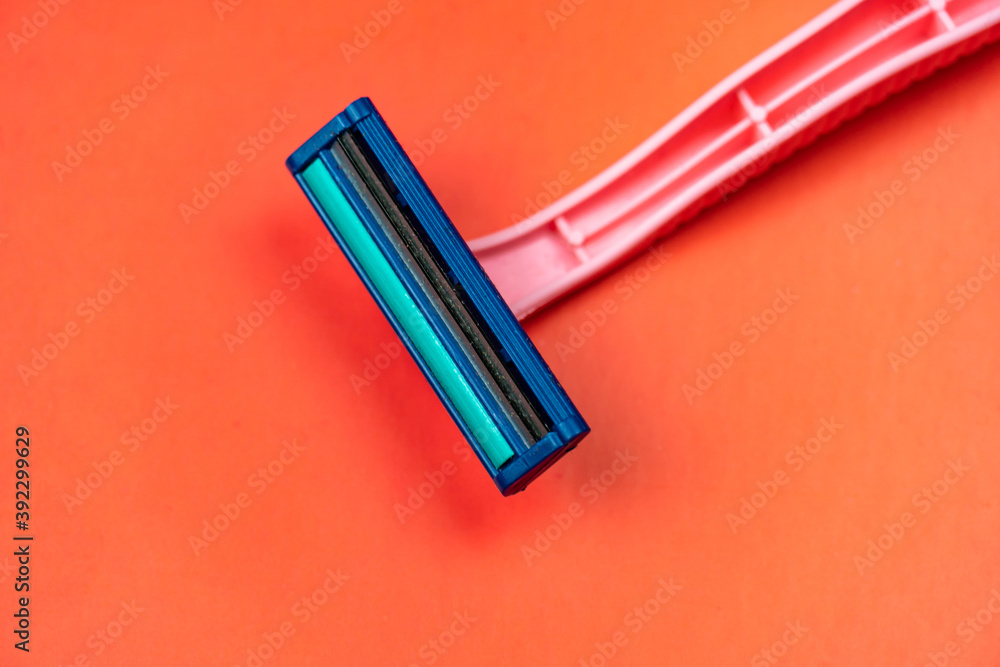 A pink razor on a red background angled for design in your work. A pink razor on a red background angled for design in your work.