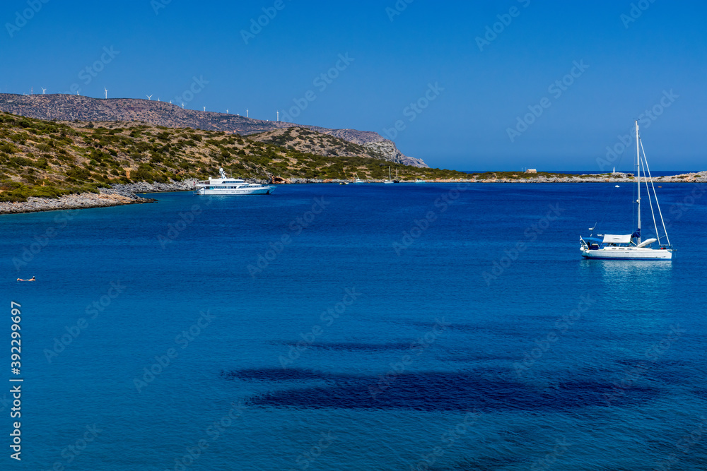 Sailing boats and swimmers in a crystal clear ocean
