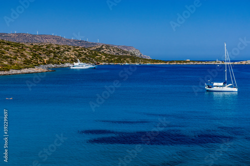 Sailing boats and swimmers in a crystal clear ocean