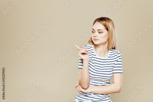 Cheerful woman striped t-shirt studio beige background lifestyle emotions © SHOTPRIME STUDIO