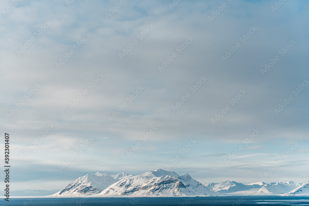 Overcast sky over snowy rock and ocen Overcast sky over snowy rock and ocen