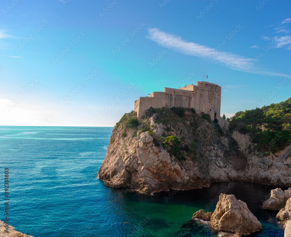 Dubrovnik's Fortica castle on the peak of a peninsula, seen while walking on the old city walls of Dubrovnik. Standing high surrounded by the blue adriatic sea