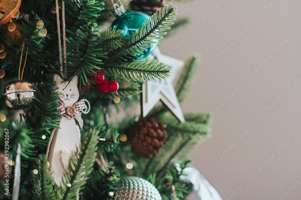 White wooden toy cat hangs on the Christmas tree copy space. Wooden Christmas toys.