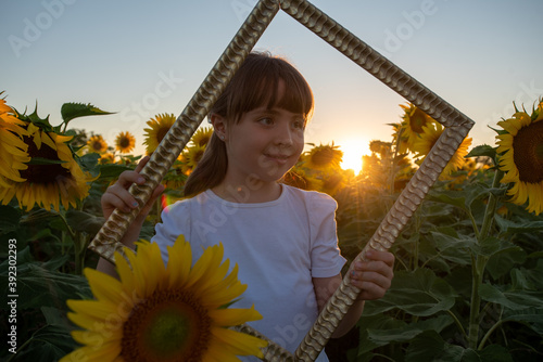 September 2020, Bibbiano, Italy. Sweet little girl poses for a photograph in a sunflower field photo