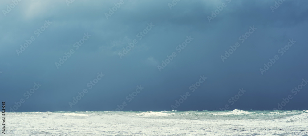 Autumn sea landscape. Rough sea with waves during autumn stormy weather. Dark heavy clouds in the sky. Dark and dramatic storm clouds background. Autumn sea landscape. Rough sea with waves during autumn stormy weather. Dark heavy clouds in the sky. Dark and dramatic storm clouds background.