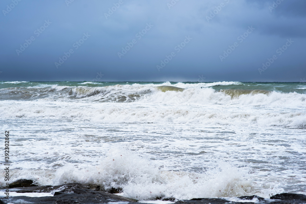 Autumn sea landscape. Rough sea with waves during autumn stormy weather. Dark heavy clouds in the sky. Dark and dramatic storm clouds background.