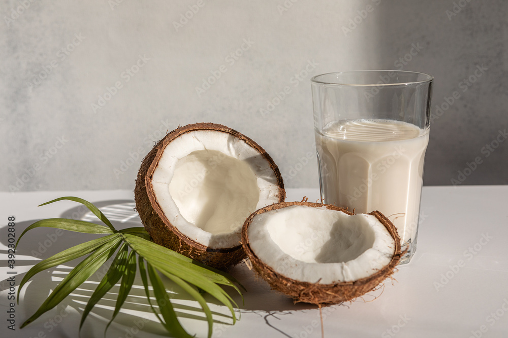 coconut and coconut milk in a glass Cup on a light background. hard light, selective focus coconut and coconut milk in a glass Cup on a light background. hard light, selective focus