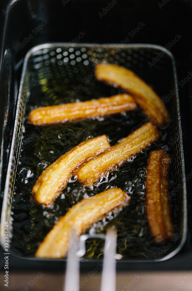 Deep frying churros in hot sunflower oil Stock Photo Adobe Stock