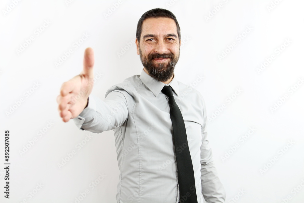 smiling bearded businessman with shirt and tie on white background stretches his arm forward to give handshake in greeting. smiling bearded businessman with shirt and tie on white background stretches his arm forward to give handshake in greeting.