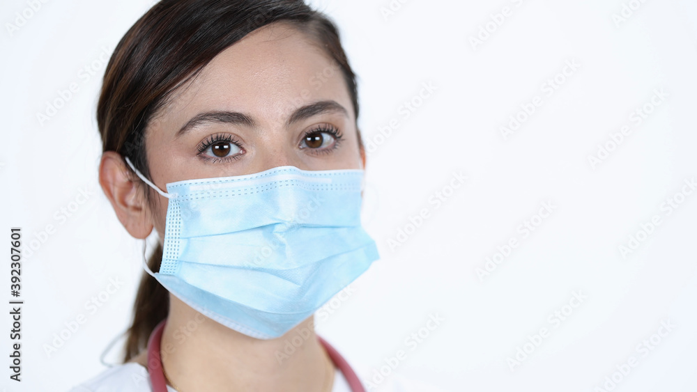 Young woman wearing face mask looking at camera on white back drop. Young woman wearing face mask looking at camera on white back drop.