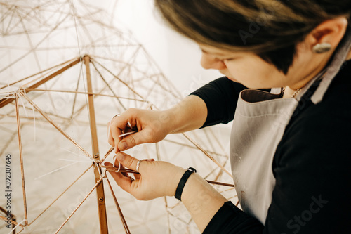 Close Up Of Female Sculptor Working On A Piece Of Metal Sculpture photo