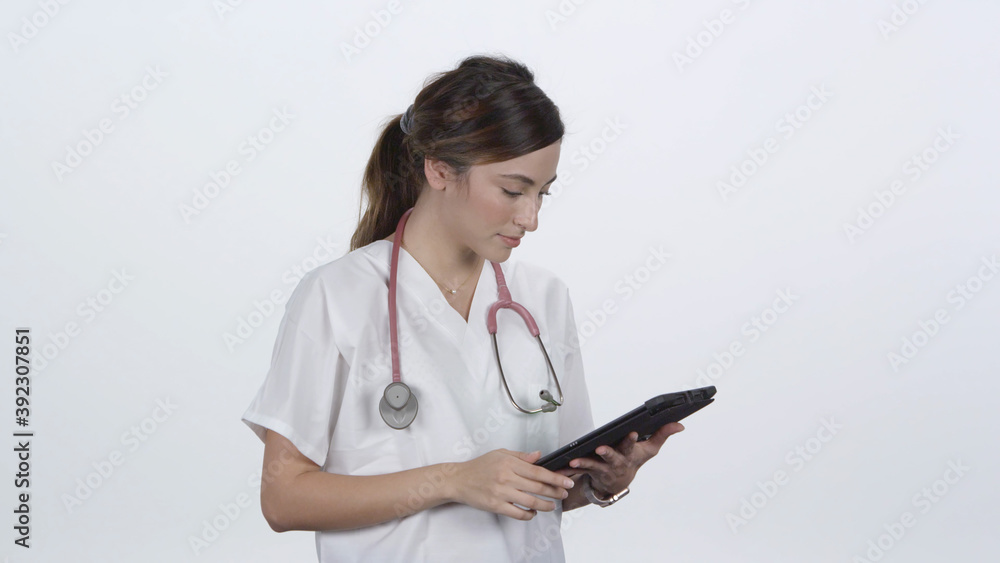 Female medical personnel giving a thumbs up while using tablet as she smiles. Female medical personnel giving a thumbs up while using tablet as she smiles.
