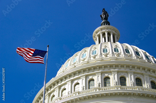 American flag in front of Capitol Hill in Washington DC with dome in daylight and facade details