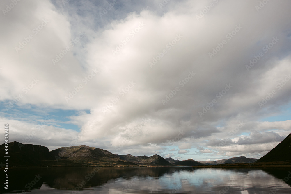 Cloudy sky over mountains and calm lake Cloudy sky over mountains and calm lake