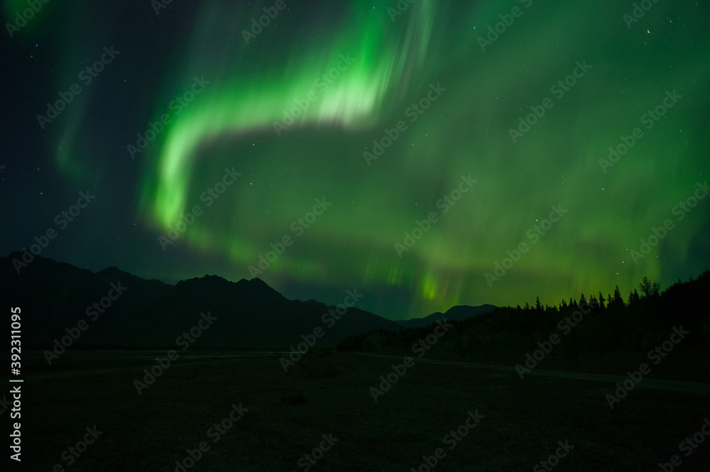 Big Aurora over Alaska mountain.