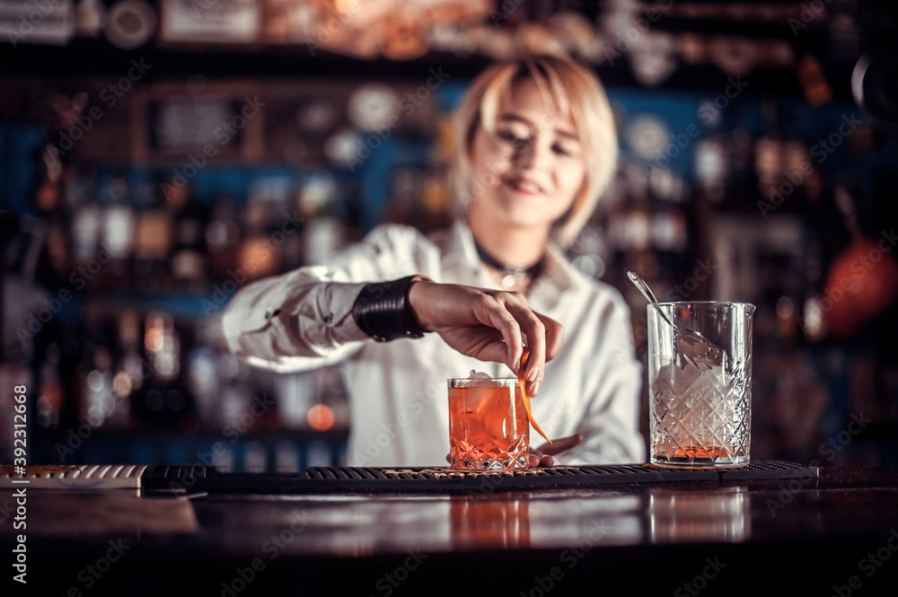 Girl barman makes a cocktail in the beerhall