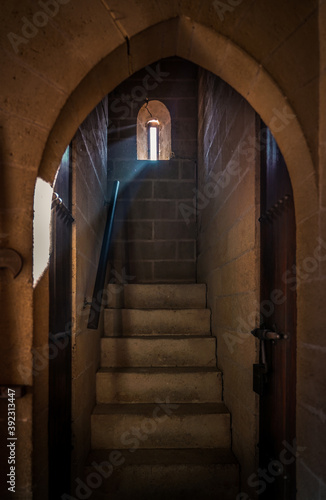 Loophole on an ancient castle, beautiful scene of stair with a ray of light