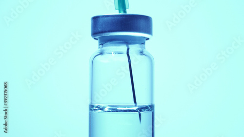 Filling syringe with vaccine from vial, close up. Administrating medication with medical needle syringe and vaccine injection for patient vaccination in medical hospital.  Health and medical concepts.