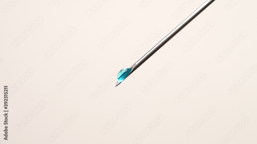 Vaccine dripping from sterile needle syringe macro close up. Administrating medication with medical needle syringe and vaccine injection for patient vaccination in medical hospital. Health concepts. Vaccine dripping from sterile needle syringe macro close up. Administrating medication with medical needle syringe and vaccine injection for patient vaccination in medical hospital. Health concepts.
