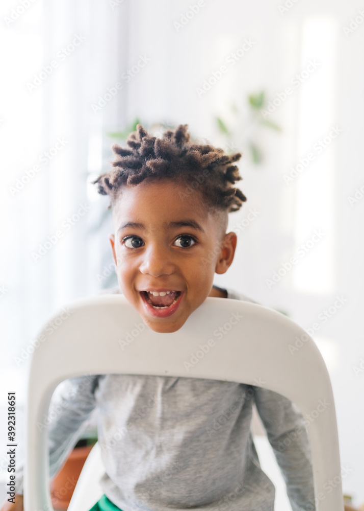 Lovely mixed race boy with dreadlooks making faces at home Lovely mixed race boy with dreadlooks making faces at home