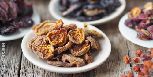 Dried apricots on the foreground.Background with bowls with various dried fruits on a wooden ancient background. Home preparation of dried fruits.