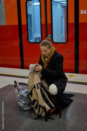 a woman searches for her passport in her backpack before a red high-speed train to the airport in moscow russia photo