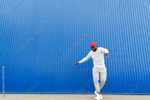 Black Man Dancing on Blue Wall