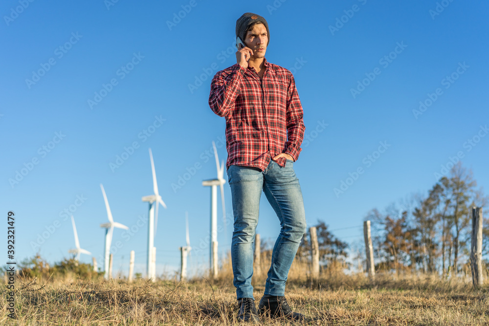 Caucasian man in red plaid shirt posing in a wind farm