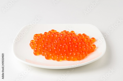 Red caviar on a white plate. Source of fat, protein and carbohydrates.