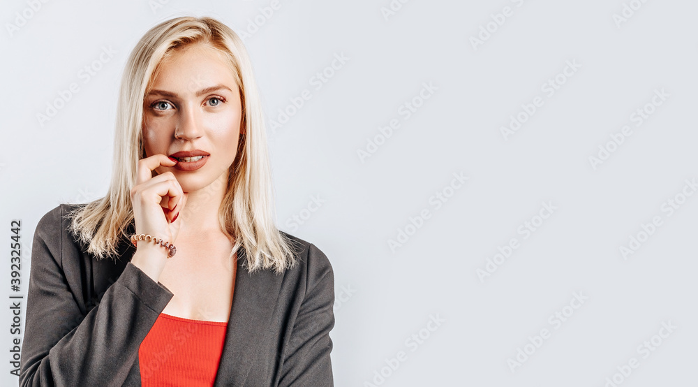 Beautiful young girl unhappy and thinks on gray isolated background Beautiful young girl unhappy and thinks on gray isolated background