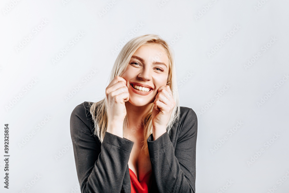 Beautiful happy young girl smiles on gray isolated background Beautiful happy young girl smiles on gray isolated background
