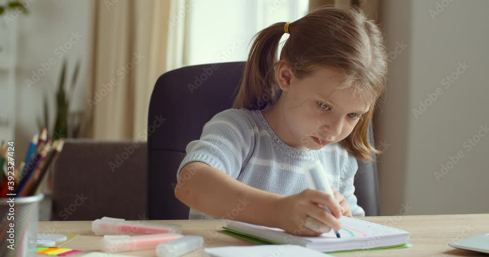 Portrait of cute concentrated little caucasian kid girl draw color pencil marker sitting at home table. Pretty preschool child coloring picture enjoy creative activity relax children distant education Portrait of cute concentrated little caucasian kid girl draw color pencil marker sitting at home table. Pretty preschool child coloring picture enjoy creative activity relax children distant education