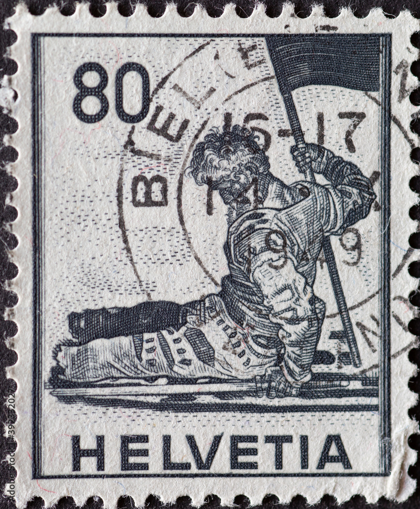 Switzerland - Circa 1941: a postage stamp printed in the swiss showing a sculpture of a dying soldier with a flag. Museum in Geneva