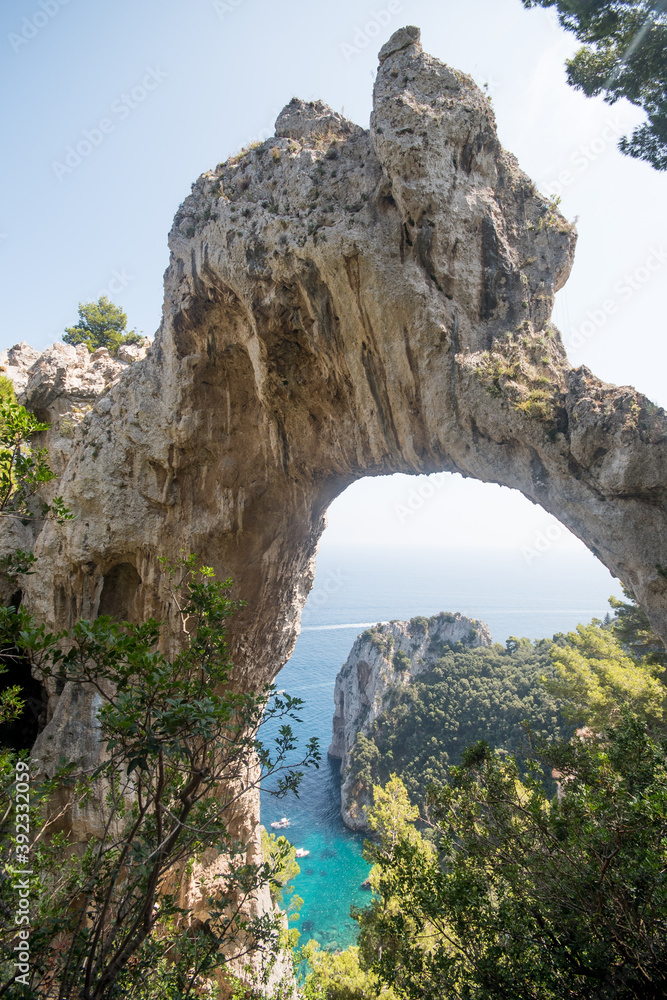 View of natural rock arch with the sea in the background.