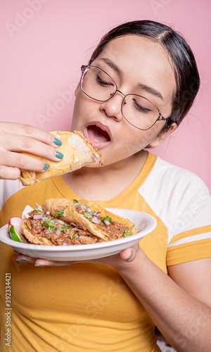 young girl eating tacos de birria
