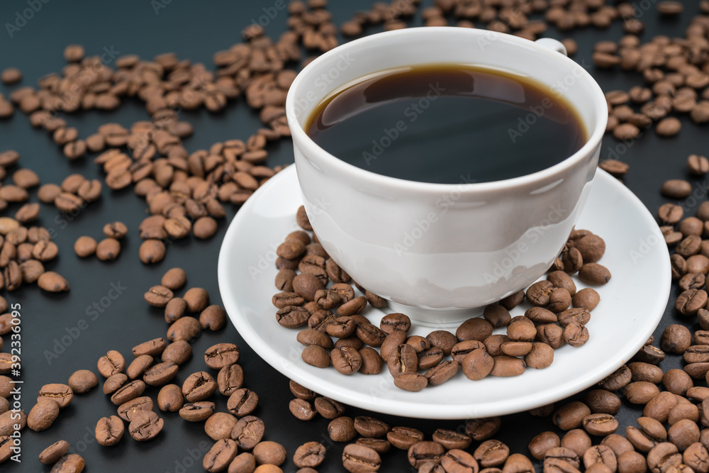 Coffee concept, white cup and freshly roasted beans, invigorating drink Coffee concept, white cup and freshly roasted beans, invigorating drink