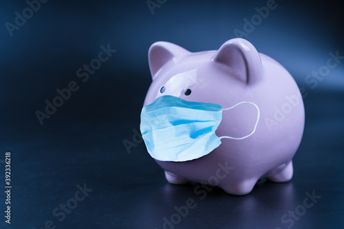 Pig piggy bank with medical mask. Close up. Money saving concept in time of coronavirus pandemic COVID-19. Making money in an epidemic