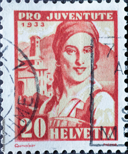 Switzerland - Circa 1933 : a postage stamp printed in the swiss showing the portrait of a Ticino woman in historical costume and a village in Ticino