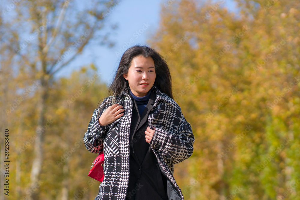 outdoors lifestyle portrait of young happy and pretty Asian Chinese woman walking relaxed and cheerful at beautiful city park in vibrant yellow and orange Autumn tree leaves outdoors lifestyle portrait of young happy and pretty Asian Chinese woman walking relaxed and cheerful at beautiful city park in vibrant yellow and orange Autumn tree leaves