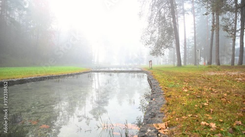 Misty morning haze over lazy river. Autumn landscape in idyll nature. Scenic and atmospheric scenery near Sobec campground in Slovenia. Left pan, wide angle, real time photo