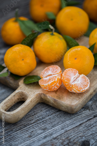 Tangerines with leaves on an old wooden background